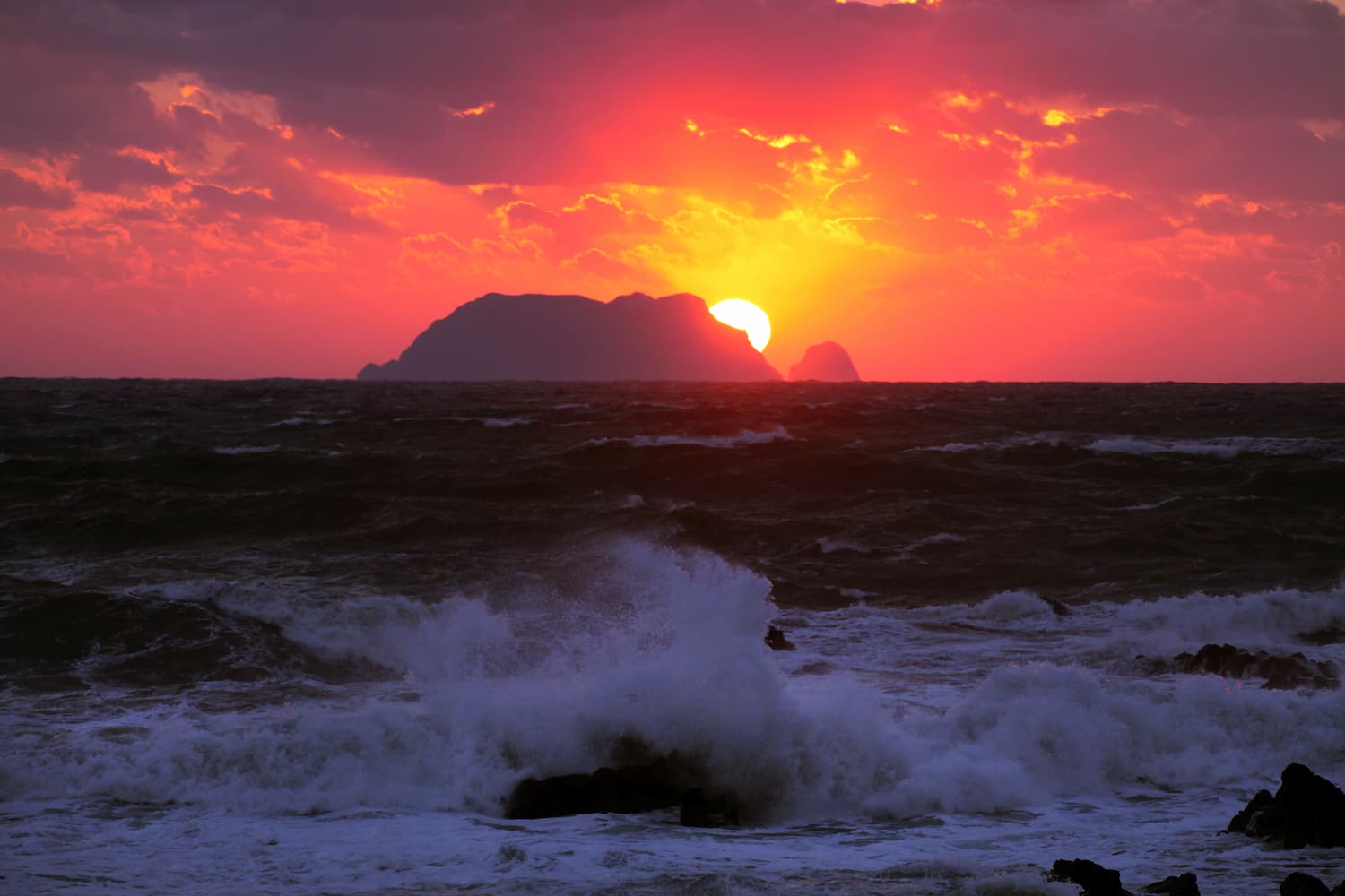 冬の日本海に落ちる夕陽と松前小島